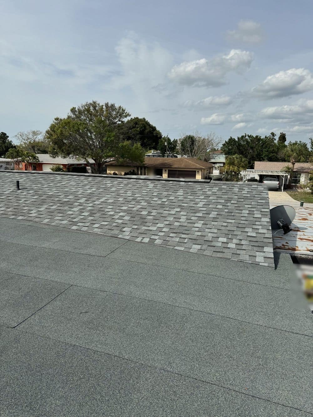 Granulated cap sheet on a low-slope section that ties into a gray shingle roof
