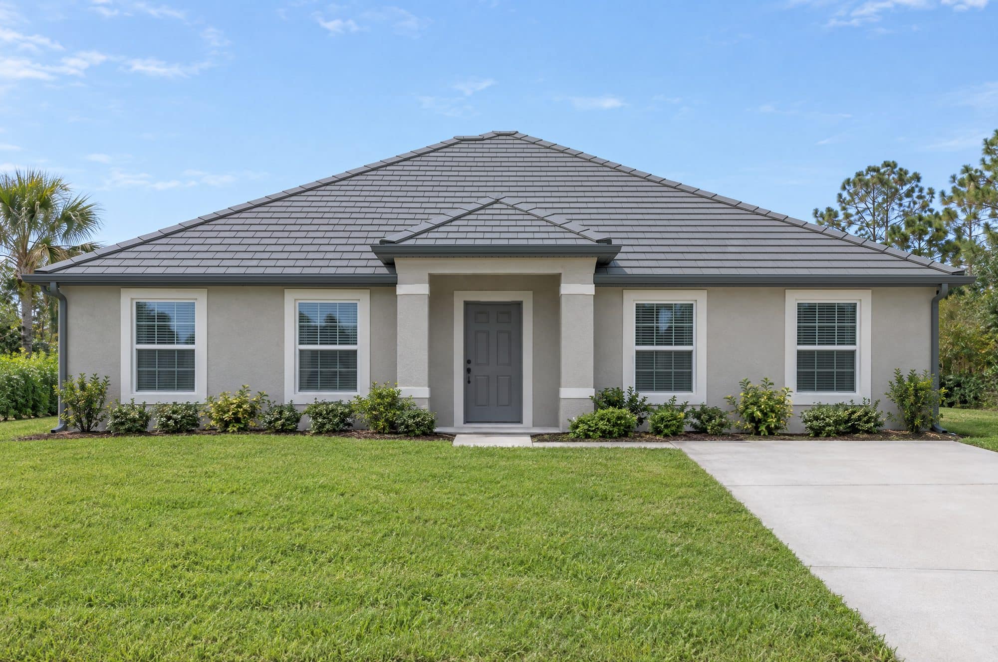 The design-studio sample house with a slate-gray flat concrete tile roof and charcoal gray gutters and downspouts (illustration)
