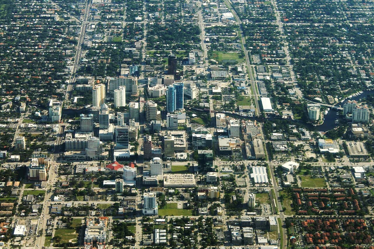 Aerial view of a dense cluster of downtown high-rise buildings surrounded by a grid of streets and neighborhoods.