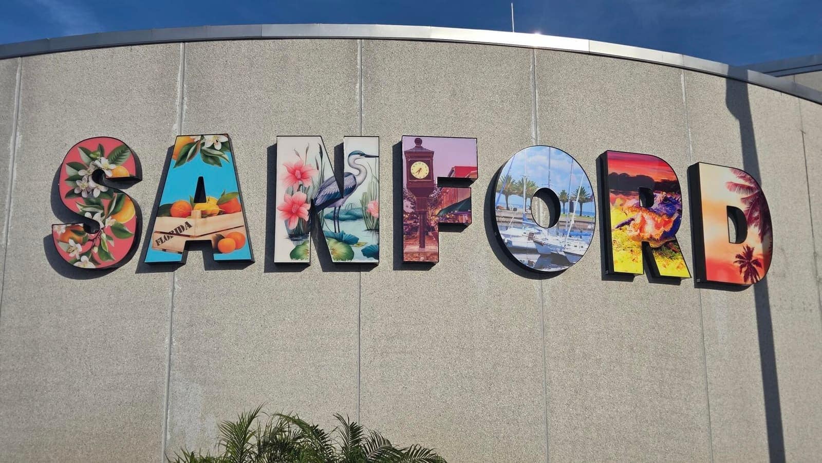 Large colorful letters spelling Sanford mounted on a concrete wall, each letter decorated with artwork.