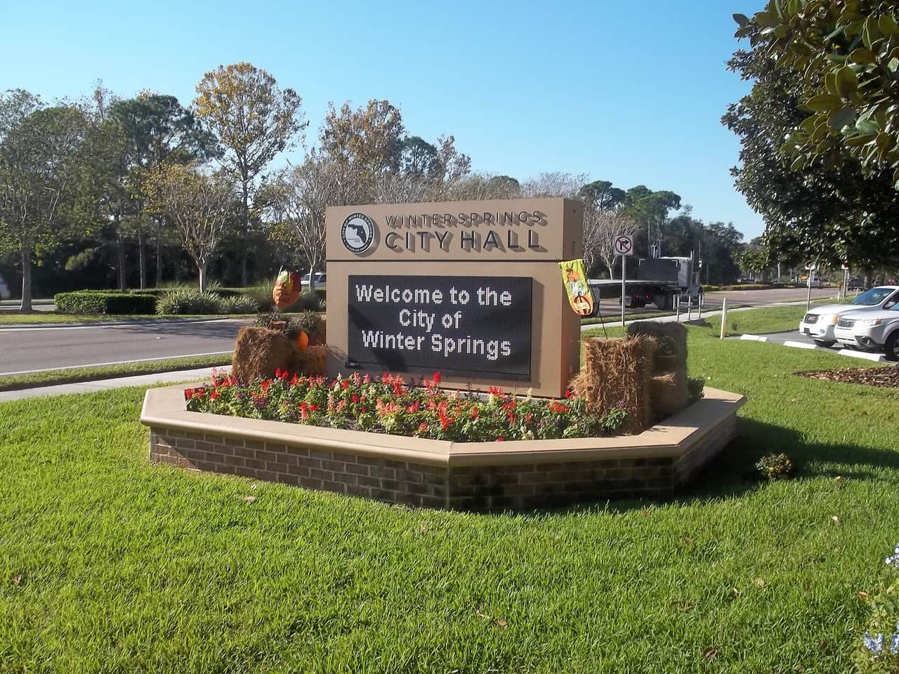 Winter Springs City Hall entrance sign reading Welcome to the City of Winter Springs, with flowers and hay bales.